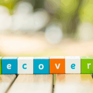Concept word RECOVERY in colorful tiles for recovery month